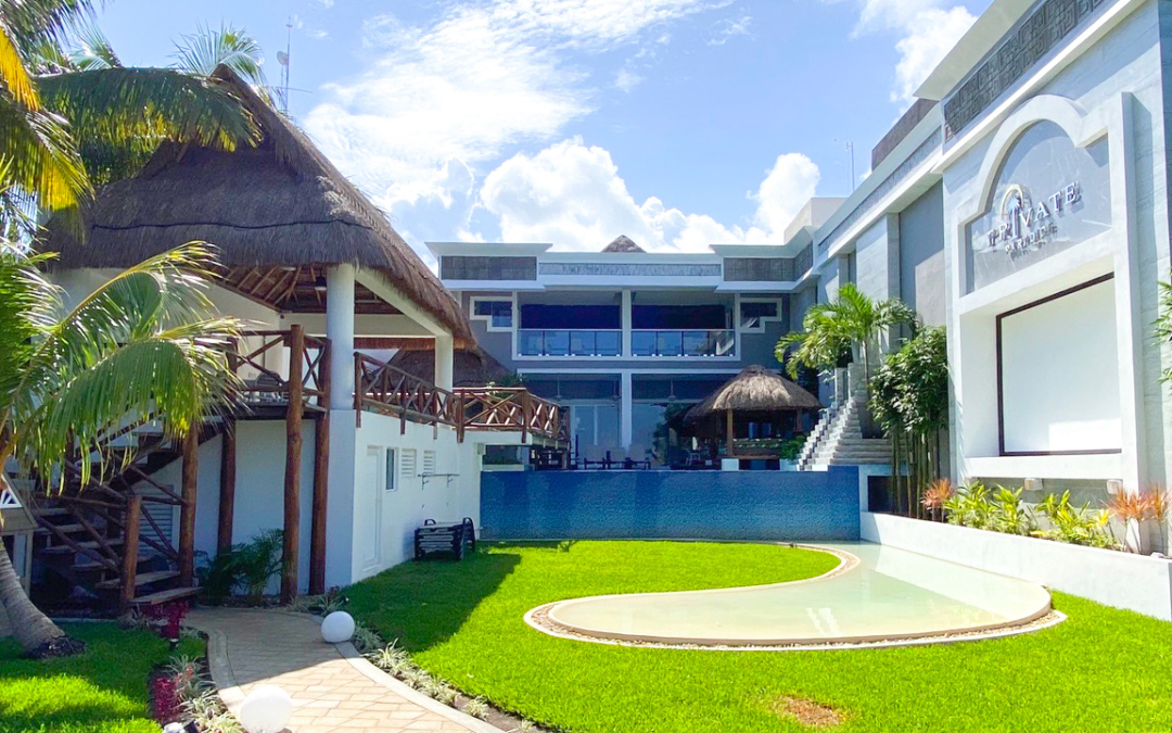 jardín con alberca, palmeras y palapa