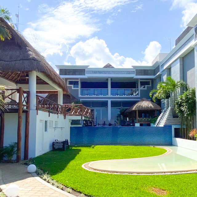 jardín con alberca, palmeras y palapa